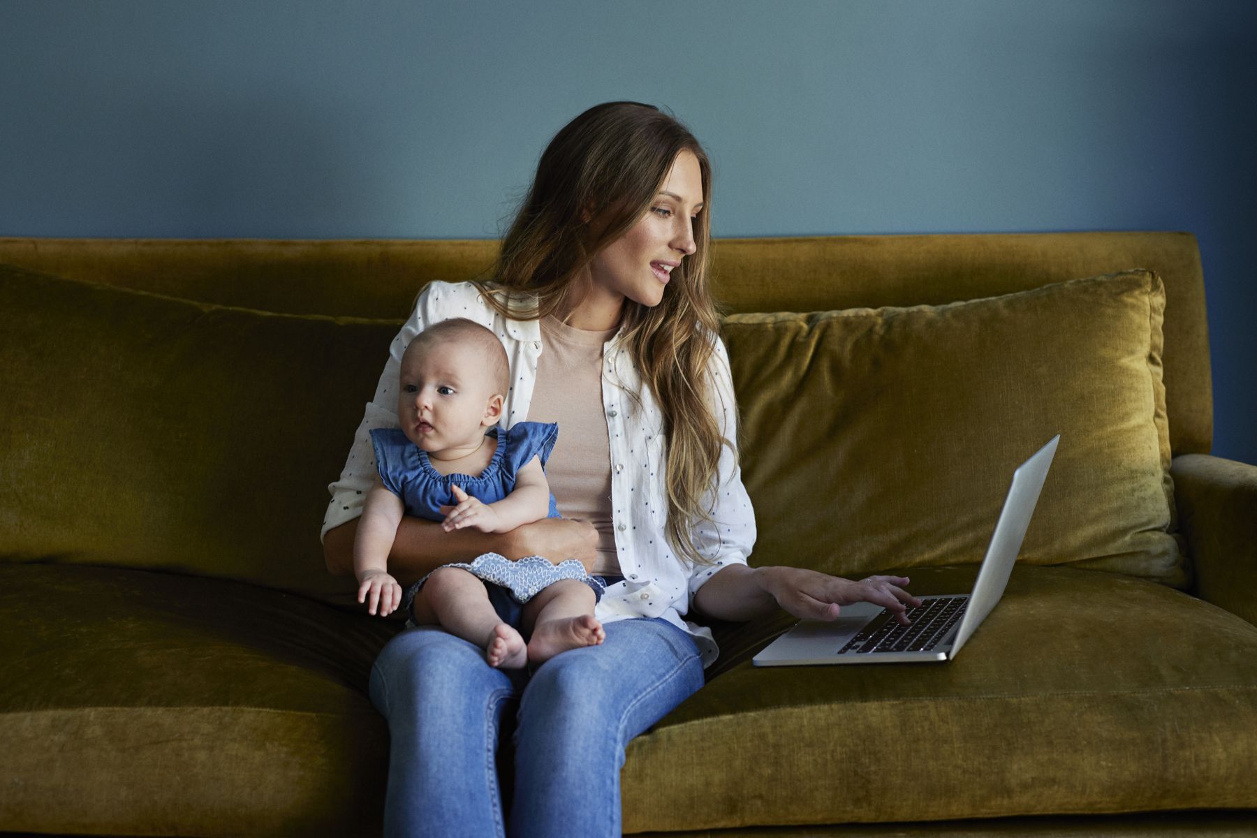 A mother holding her baby on a sofa