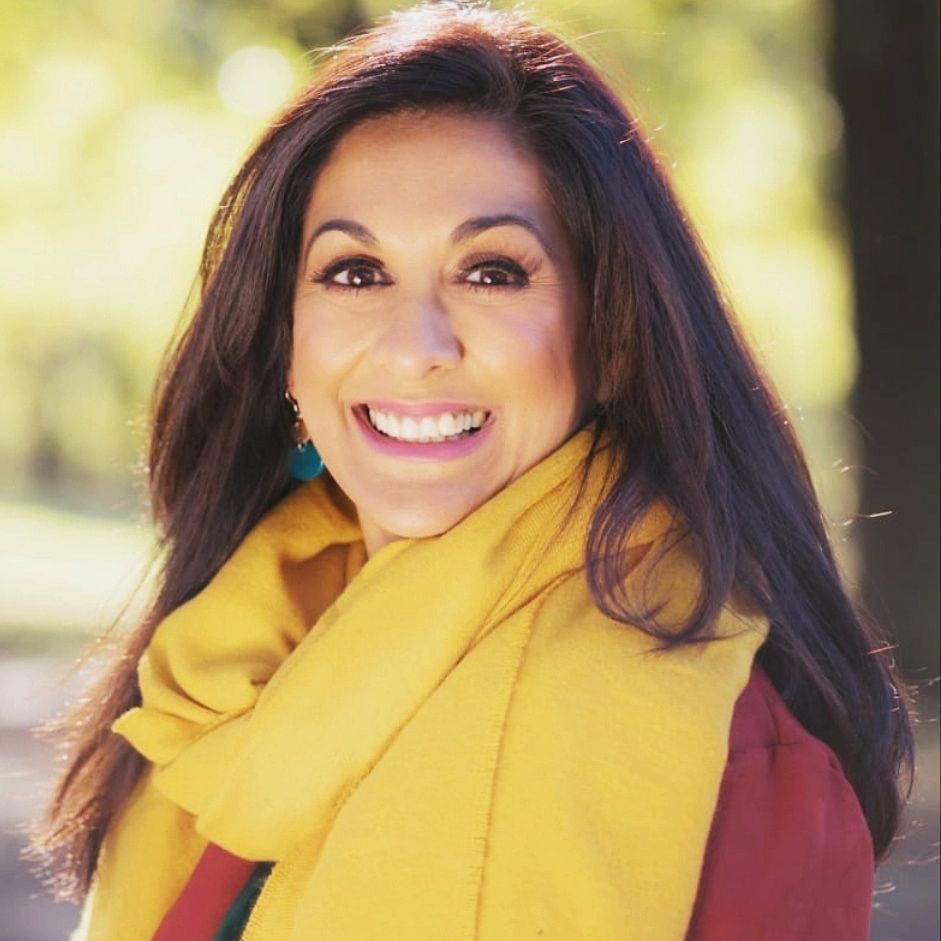 Priya Khan, smiling, wearing a yellow scarf